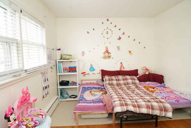 bedroom featuring wood finished floors and a baseboard radiator