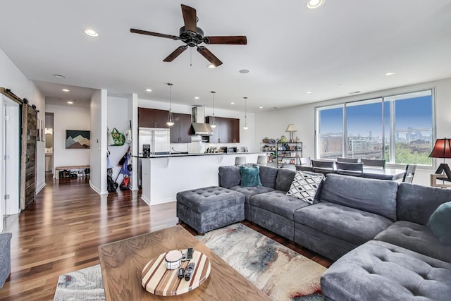 living area with recessed lighting, a barn door, a ceiling fan, and wood finished floors