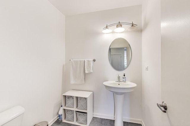 bathroom with baseboards and toilet
