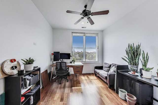 home office with a ceiling fan, wood finished floors, and visible vents
