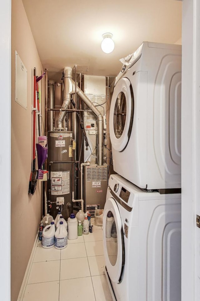 laundry room with laundry area, stacked washer and dryer, baseboards, gas water heater, and tile patterned floors