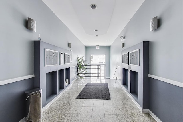 hallway with baseboards and mail area