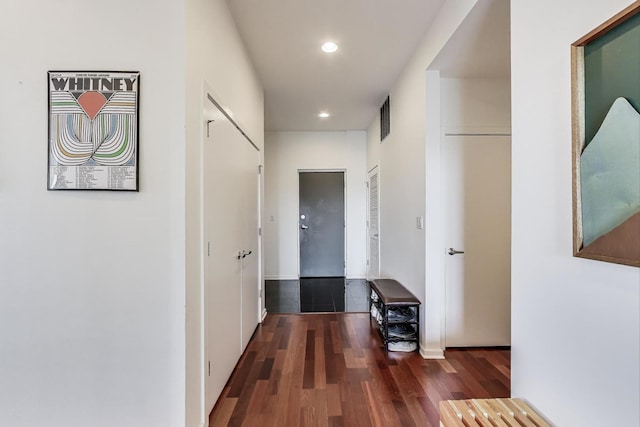 hall with recessed lighting, wood finished floors, and visible vents