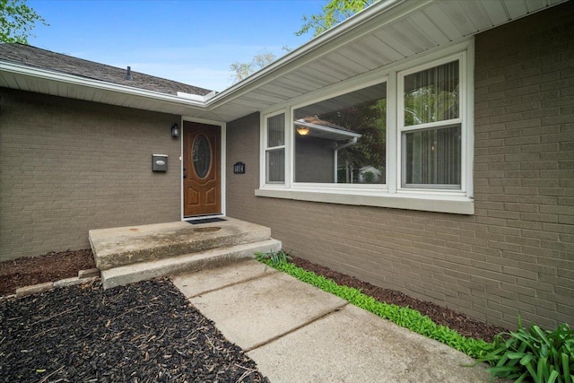 doorway to property featuring brick siding