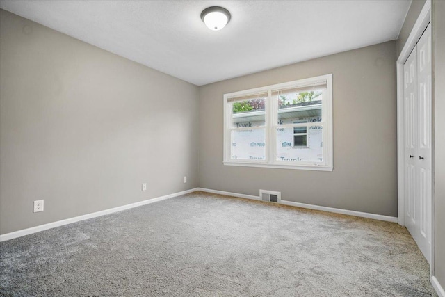 unfurnished bedroom with a closet, baseboards, carpet floors, and visible vents