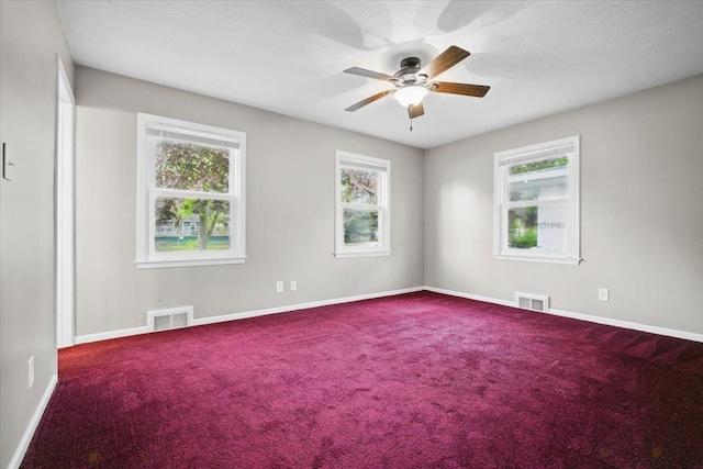 spare room with a ceiling fan, baseboards, visible vents, and carpet
