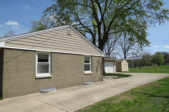 view of property exterior with a lawn, an outbuilding, a garage, brick siding, and a shed