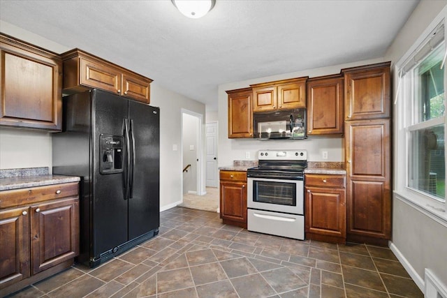 kitchen with baseboards, black appliances, and visible vents