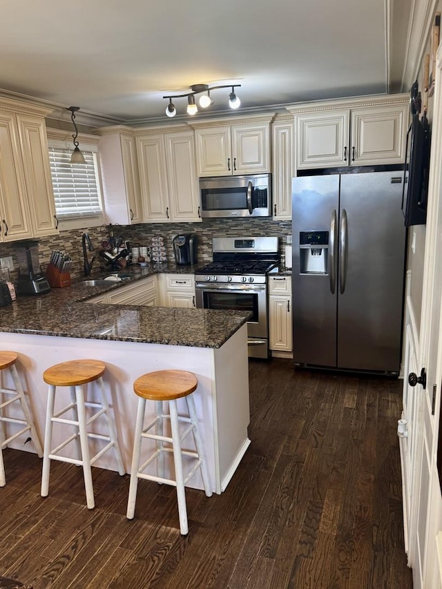 3825 W Pippin St, Chicago, IL 60652 - kitchen with a peninsula, tasteful backsplash, a sink, dark stone countertops, and appliances with stainless steel finishes