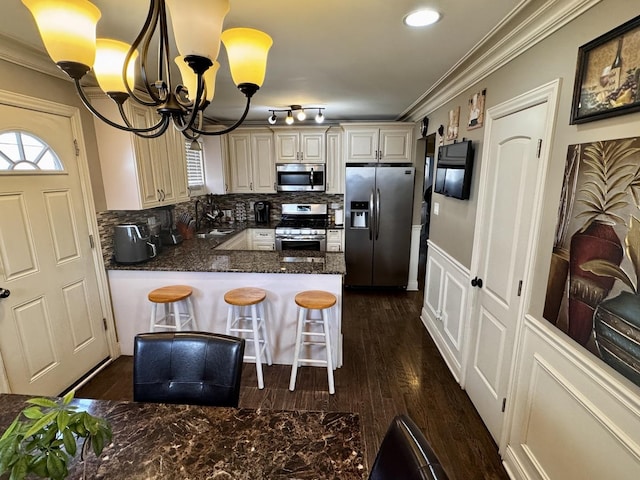 3825 W Pippin St, Chicago, IL 60652 - kitchen with crown molding, stainless steel appliances, a notable chandelier, and a peninsula