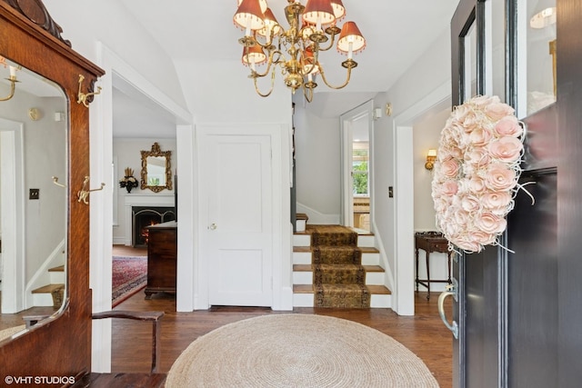 283 Ridge Ave, Winnetka, IL 60093 - foyer with a chandelier, stairs, dark wood-type flooring, and a warm lit fireplace
