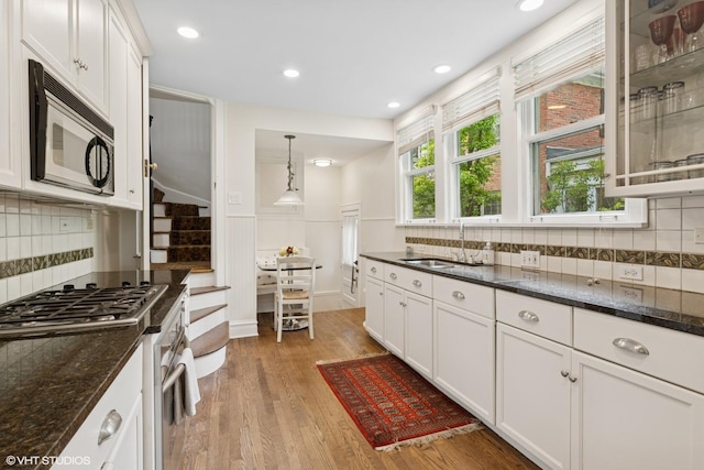 283 Ridge Ave, Winnetka, IL 60093 - kitchen featuring appliances with stainless steel finishes, light wood-style floors, white cabinetry, a sink, and recessed lighting
