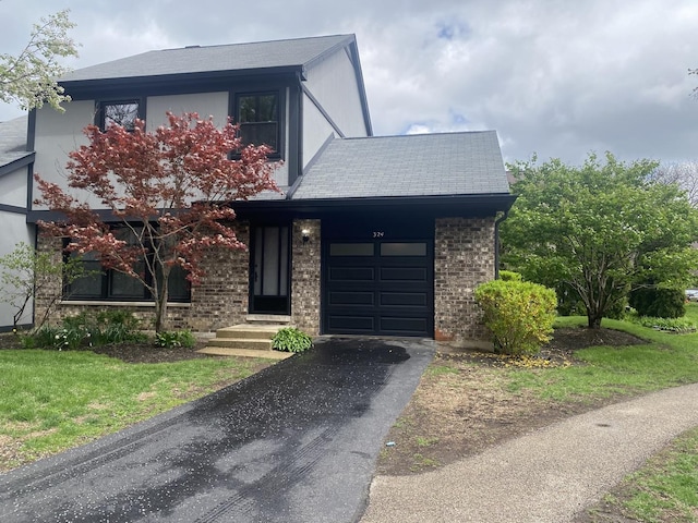 view of front facade featuring brick siding, an attached garage, and driveway