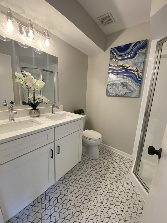 bathroom featuring visible vents, a shower stall, and a sink