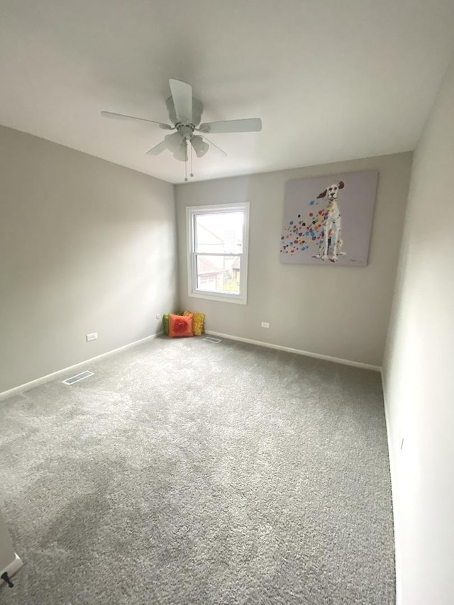 carpeted empty room featuring a ceiling fan, baseboards, and visible vents