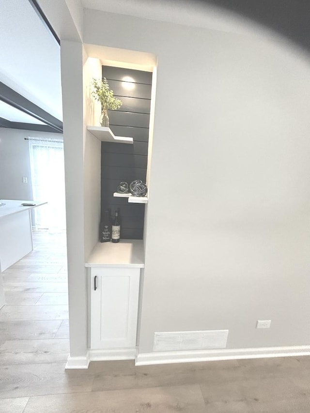 room details featuring baseboards, visible vents, and wood finished floors