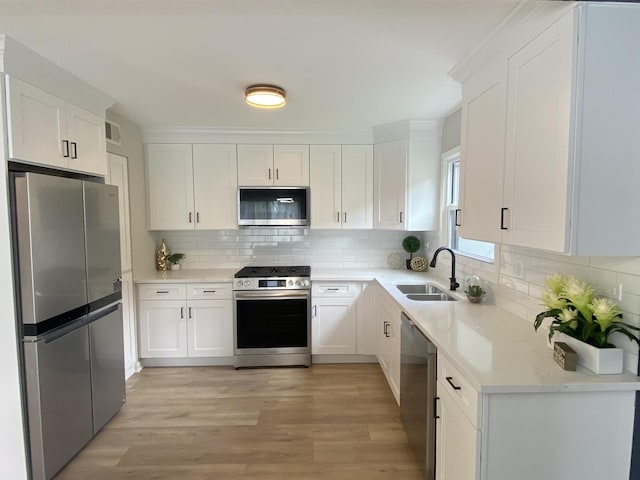 kitchen with a sink, stainless steel appliances, light wood-style flooring, and visible vents