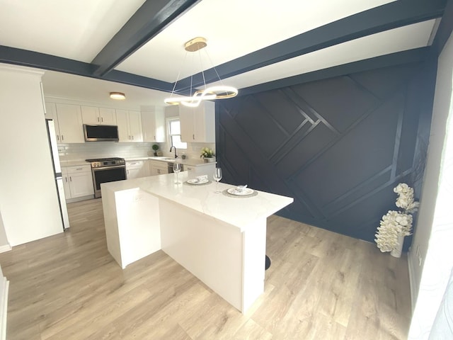 kitchen featuring an inviting chandelier, light wood-style flooring, a center island, stainless steel appliances, and white cabinetry