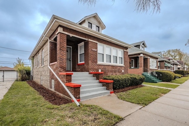 bungalow-style home featuring brick siding, a front lawn, and fence