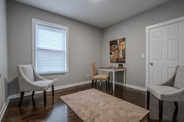 sitting room with baseboards, visible vents, and dark wood-style floors