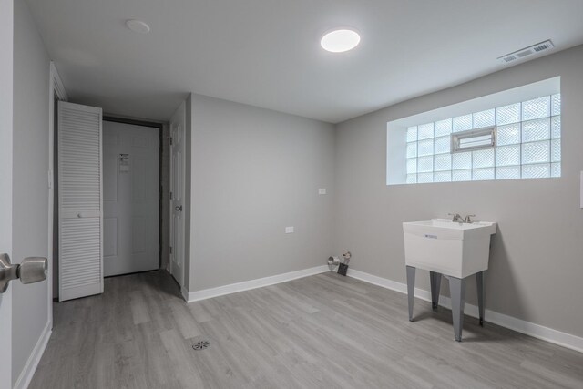 laundry room with baseboards, visible vents, and light wood-style flooring