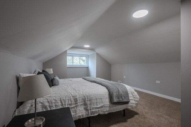 carpeted bedroom featuring baseboards and vaulted ceiling