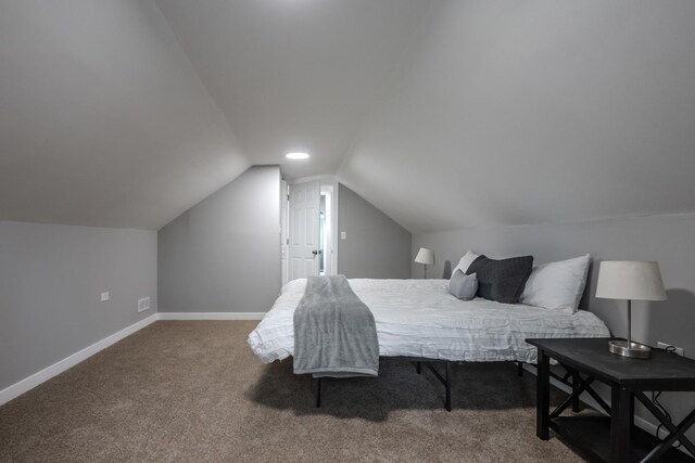 carpeted bedroom featuring baseboards and lofted ceiling