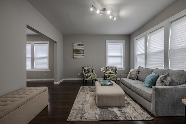 living area featuring baseboards and dark wood finished floors