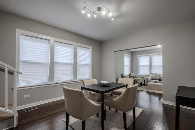 dining space featuring baseboards, visible vents, and dark wood-type flooring