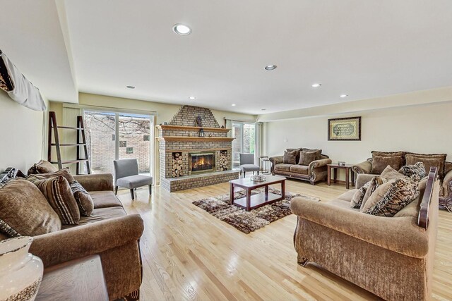 living room featuring recessed lighting, light wood finished floors, and a fireplace