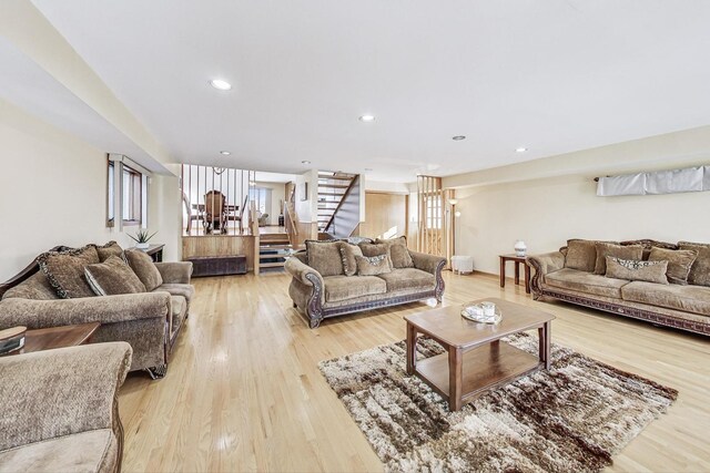 living room featuring stairway, recessed lighting, light wood-style flooring, and a healthy amount of sunlight
