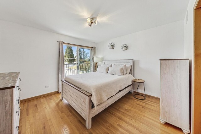 bedroom with baseboards, light wood finished floors, and access to exterior