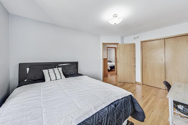 bedroom featuring a closet, light wood-style flooring, and visible vents