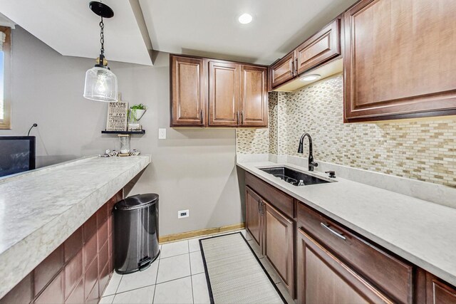 clothes washing area with baseboards, a sink, light tile patterned flooring, and recessed lighting