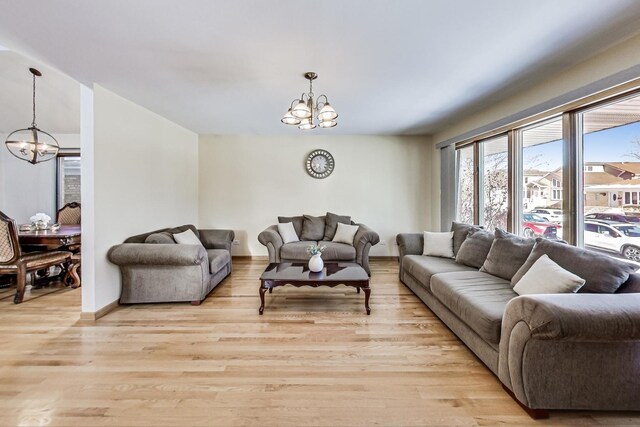 living area featuring baseboards, wood finished floors, and a chandelier