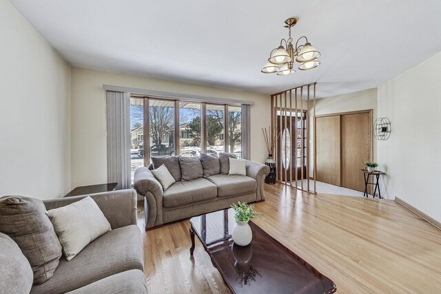 living room with light wood-type flooring and a notable chandelier