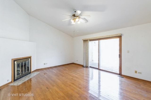 2339 N James Ct, Arlington Heights, IL 60004 - unfurnished living room featuring light wood-style flooring, a ceiling fan, a tiled fireplace, baseboards, and lofted ceiling