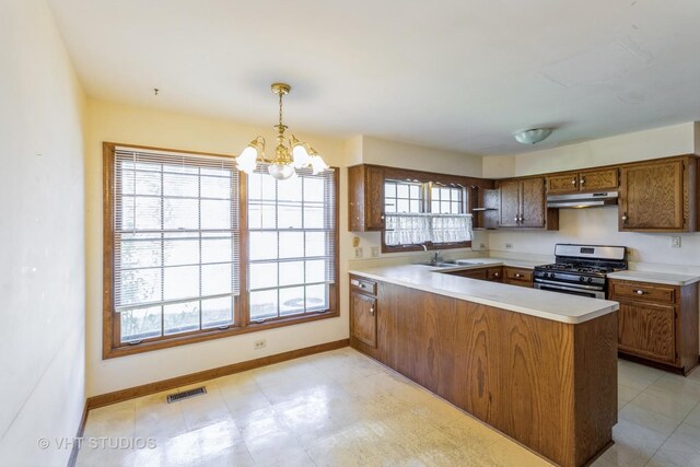 2339 N James Ct, Arlington Heights, IL 60004 - kitchen with gas range, under cabinet range hood, brown cabinets, a chandelier, and a peninsula