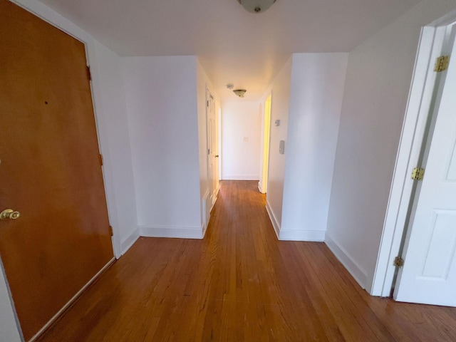 hall featuring baseboards and wood finished floors