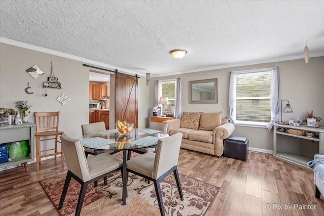 2381 Elm Rd, West Chicago, IL 60185 - dining space with a barn door, light wood-style flooring, crown molding, a textured ceiling, and baseboards