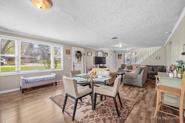 2381 Elm Rd, West Chicago, IL 60185 - dining room with stairway, healthy amount of natural light, wood finished floors, a textured ceiling, and baseboards