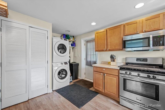 2381 Elm Rd, West Chicago, IL 60185 - kitchen featuring appliances with stainless steel finishes, stacked washer and clothes dryer, light countertops, recessed lighting, and light wood-style floors