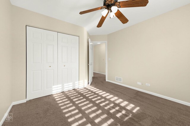 unfurnished bedroom featuring carpet, a ceiling fan, baseboards, visible vents, and a closet
