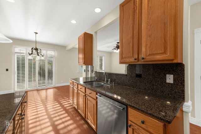 kitchen with stainless steel dishwasher, a sink, a wealth of natural light, and tasteful backsplash