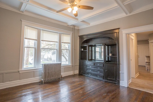 bedroom featuring radiator heating unit, coffered ceiling, dark wood-type flooring, beam ceiling, and ornamental molding