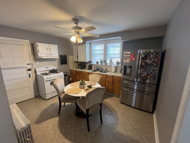 5834 S Keeler Ave, Chicago, IL 60629 - kitchen featuring stainless steel refrigerator with ice dispenser, white range with gas cooktop, under cabinet range hood, light countertops, and ceiling fan