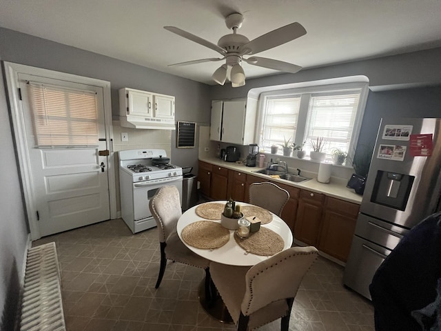 5834 S Keeler Ave, Chicago, IL 60629 - kitchen featuring white gas range, stainless steel fridge with ice dispenser, under cabinet range hood, a ceiling fan, and light countertops