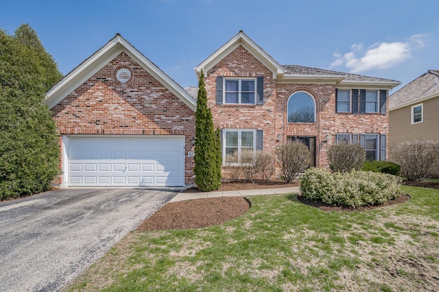 view of front of house with brick siding, a garage, and aphalt driveway