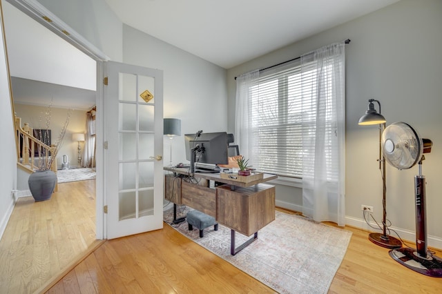 office space with baseboards, vaulted ceiling, and wood finished floors