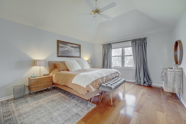 bedroom featuring baseboards, a ceiling fan, wood finished floors, and vaulted ceiling